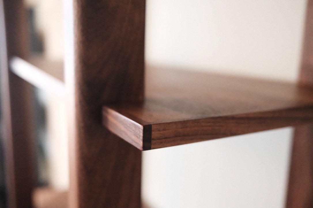 Close-up of precise walnut shelf joinery